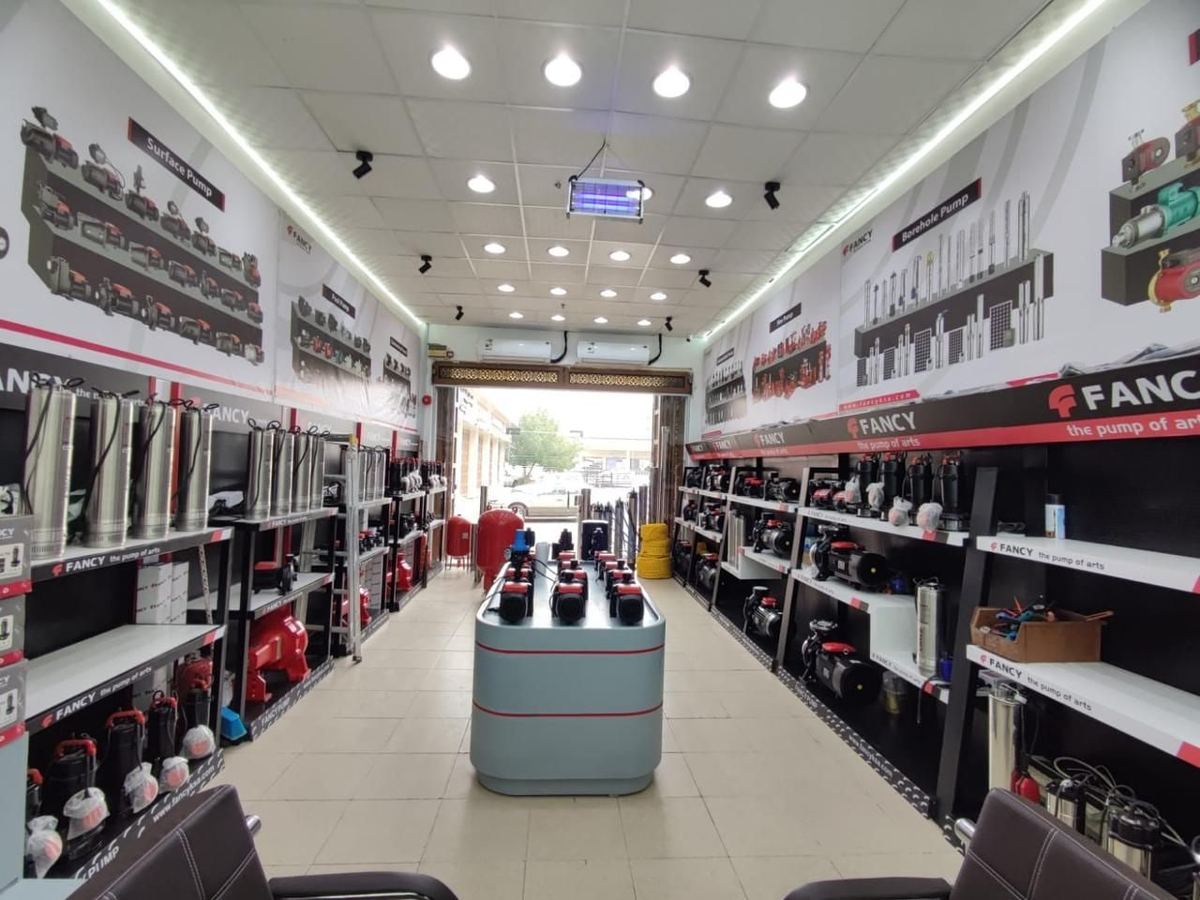 The Madinah showroom's long aisle with pump shelving on both walls and a central display island