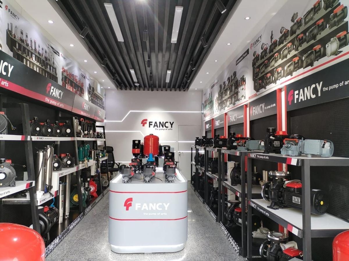 The Riyadh showroom's aisle, lined with pump shelving, a lit display island and a branded feature wall at the end