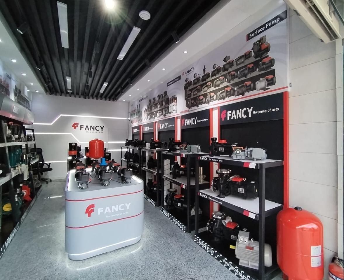 Pump display bays, a red pressure vessel and the lit display island in the Riyadh showroom