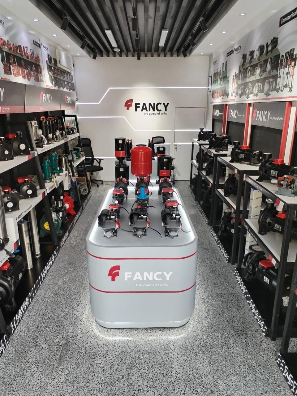 The Riyadh showroom's lit display island carrying booster pumps and a red pressure vessel