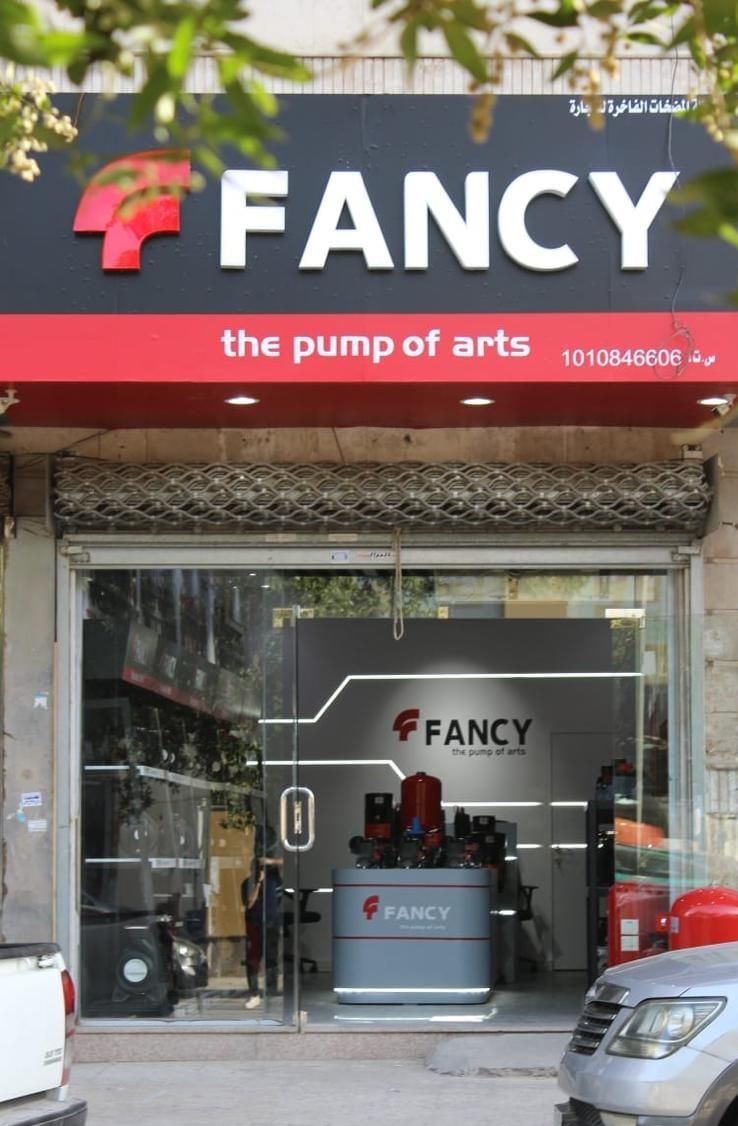 The Riyadh showroom's storefront: a red-and-black FANCY fascia over a glass front with the lit display island inside