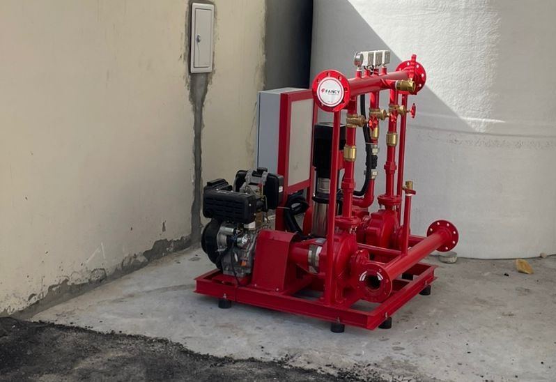 Compact red fire-pump set with diesel and electric main pumps, a jockey pump and controller on one skid